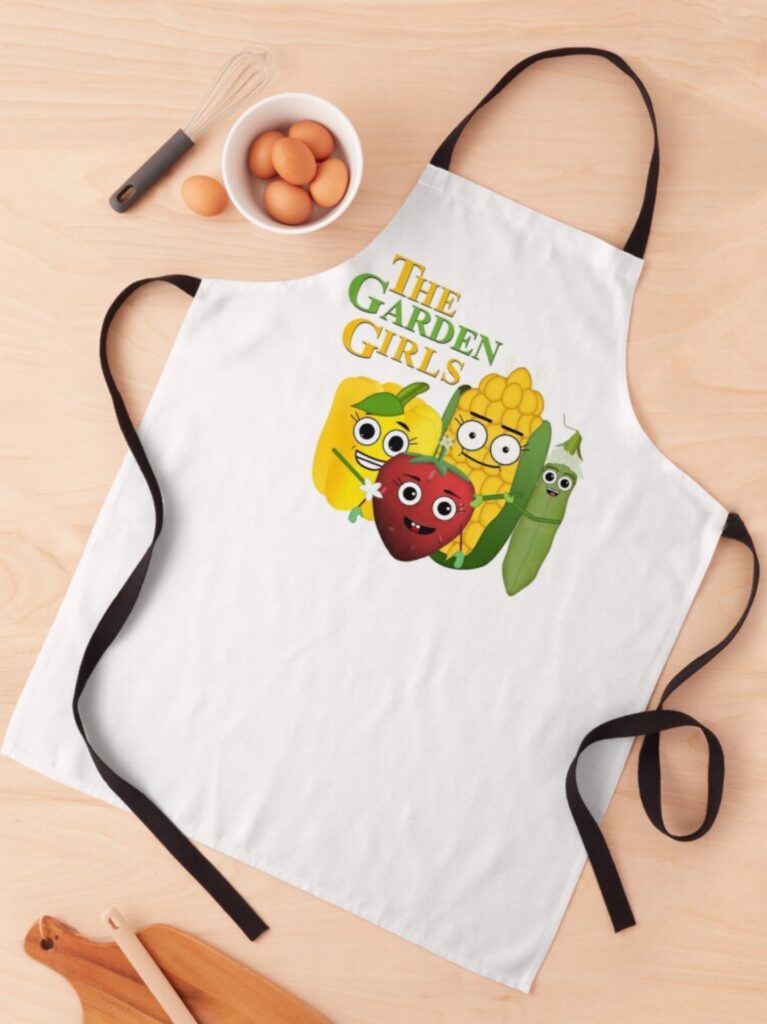 Apron featuring iconic Golden Girls reimagined as garden veggies: strawberry, peas, bell pepper, and corn cob. Perfect for fans of the classic show and gardening enthusiasts. 'Garden Girls' text design. Unique kitchenwear for those who love a blend of pop culture and fresh produce humor.